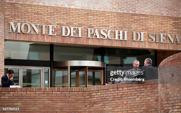 Pedestrians stand outside the administrative offices of Banca Monte dei Paschi di Siena SpA in Siena, Italy, on Monday, April 29, 2013. An Italian...