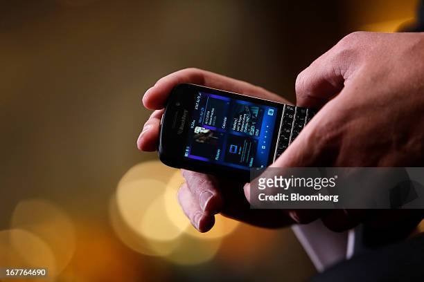 Thorsten Heins, chief excutive officer of BlackBerry, holds a Q10 smartphone while speaking during a Bloomberg Television interview at the annual...