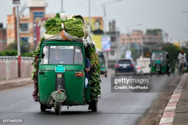 Run autorickshaw carries vegetables from a nearby village to Dhaka for sale in the wholesale market of the megacity. This photo was taken in Dhaka,...