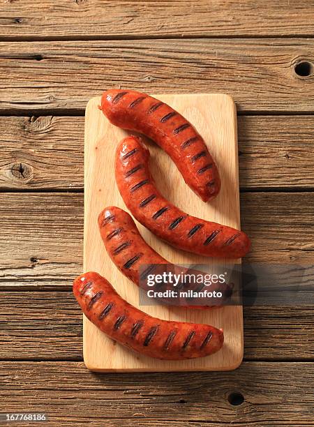 four grilled sausages on wooden table - sausage bildbanksfoton och bilder