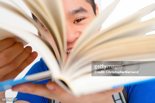 sorridente studente maschio girare le pagine - sfogliare libro foto e immagini stock