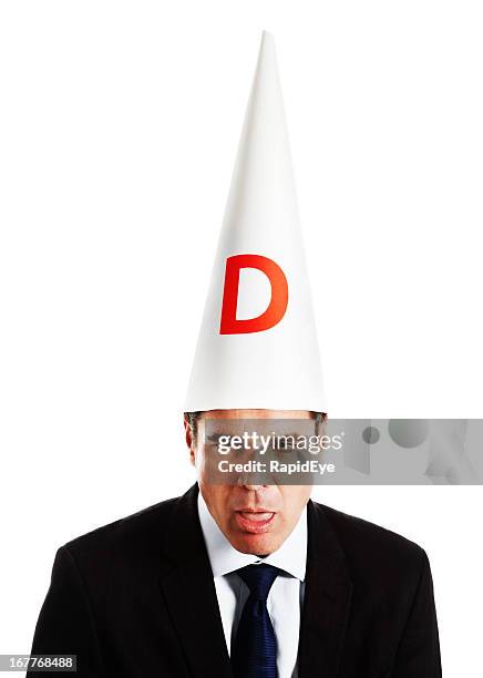 businessman in dunce cap looking really dumb - dunce cap stock pictures, royalty-free photos & images