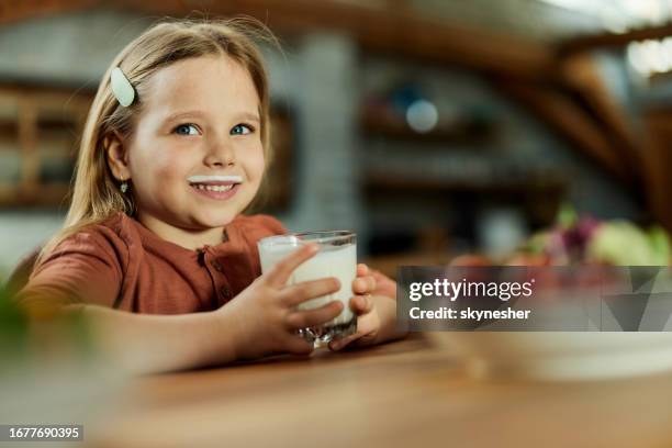 happy girl with milk mustache at home. - milk moustache stock pictures, royalty-free photos & images