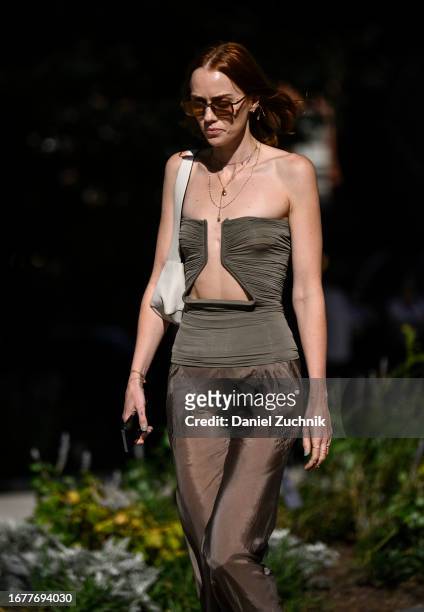 Tiernan Cowling is seen wearing a green top, brown sheer pants and cream bag with red sunglasses outside the Carolina Herrera show during NYFW S/S...