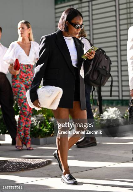 Rajni Jacques is seen wearing a black blazer, black skirt, white shirt and black sunglasses with a white faux fur bag outside the Carolina Herrera...