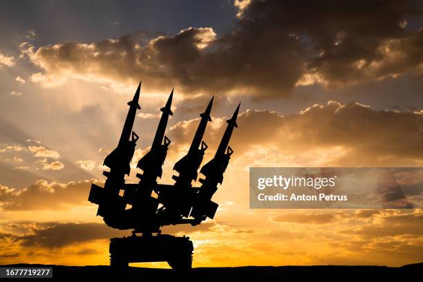missile system on the background of the sunset - war stockfoto's en -beelden