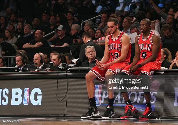 Joakim Noah and Luol Deng of the Chicago Bulls wait for play to resume with 3:15 left in the game against the Brooklyn Nets during Game Five of the...