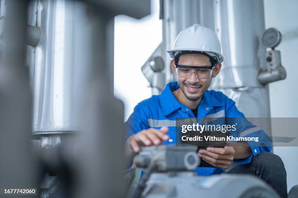 asian engineer working at oil and gas factory with pipeline and pump - wasserpumpe stock-fotos und bilder