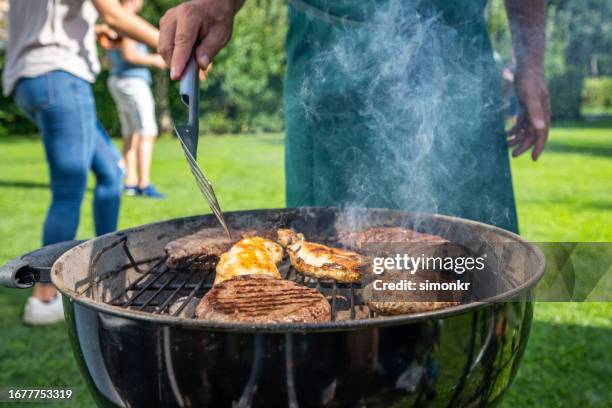 man roasting on barbecue grill - barbeque stock pictures, royalty-free photos & images