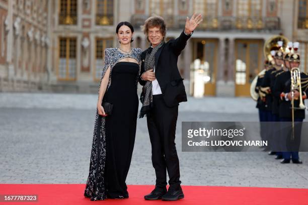 English singer Mick Jagger and his partner US choreographer Melanie Hamrick arrive to attend a state banquet at the Palace of Versailles, west of...