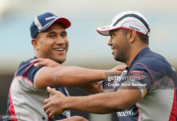 Kurtley Beale and teammate Cooper Vuna stretch during a Melbourne Rebels Super Rugby training session at AAMI Park on April 30, 2013 in Melbourne,...