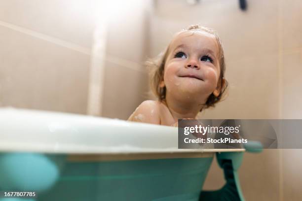 portrait of little girl taking a bath at home - bath girl stockfoto's en -beelden