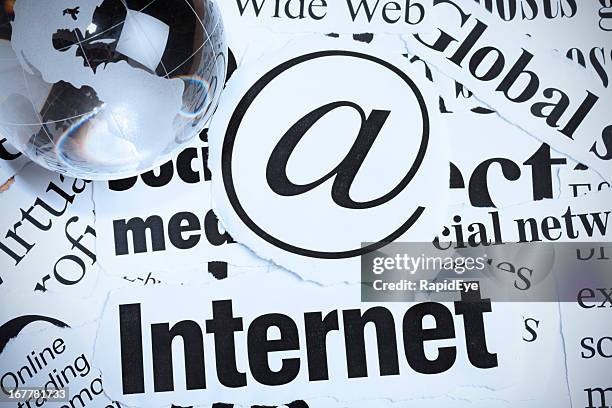glas globe briefbeschwerer auf @schild und schlagzeilen über internet - zeitungsausriss stock-fotos und bilder