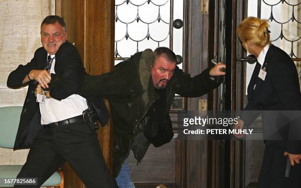 Security officials restrain former Northern Ireland Protestant paramilitant Michael Stone at Stormont Parliament buildings, in Belfast, in Northern...