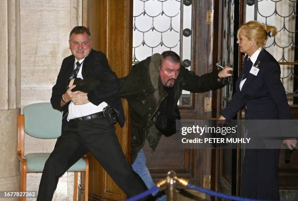 Security officials restrain former Northern Ireland Protestant paramilitant Michael Stone at Stormont Parliament buildings, in Belfast, in Northern...