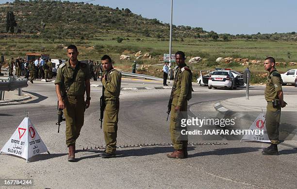 Israeli security forces gather near the site where an Israeli settler was stabbed in the Tapuah junction near the northern West Bank city of Nablus,...