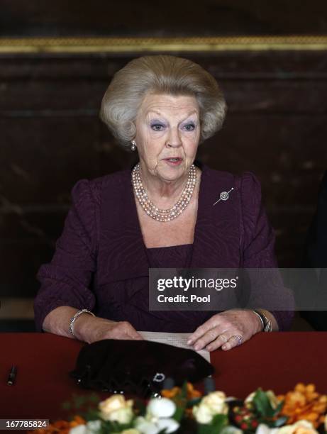 Queen Beatrix of the Netherlands signs the Act of Abdication during a ceremony in the Moseszaal at the Royal Palace on April 30, 2013 in Amsterdam....