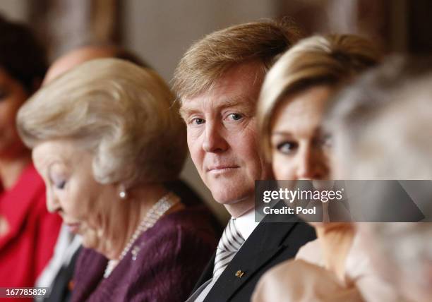 Prince Willem-Alexander of the Netherlands sits alongside his mother Queen Beatrix of the Netherlands during her abdication ceremony in the Moseszaal...