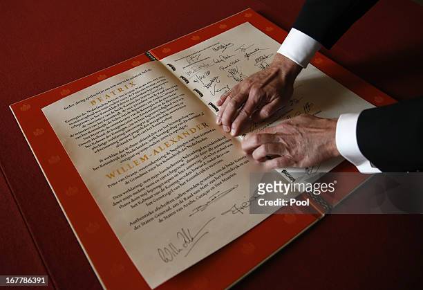 Man displays the Act of Abdication signed by Queen Beatrix of the Netherlands, her son Prince Willem-Alexander of the Netherlands and his wife...