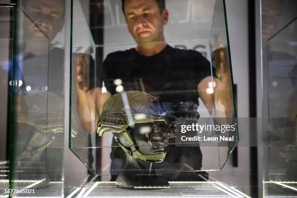 Man places a protective case over a dummy head wearing MU-3ADM night vision goggles during day two of the Defence and Security Equipment...