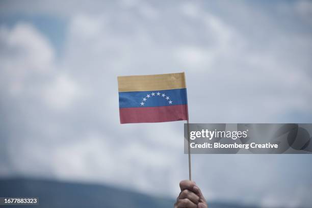 a person holds a venezuelan flag - venezuela flag stock pictures, royalty-free photos & images
