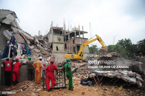 Bangladeshi rescuers work as Bangladeshi Army personel continue the second phase of the rescue operation using heavy equipment following the collapse...