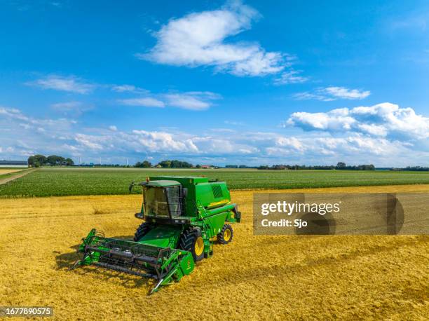 john deere mähdrescher bei der weizenernte im sommer von oben gesehen - landwirtschaftliche maschine stock-fotos und bilder