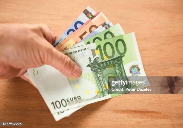 holding euro banknotes - money talks refrán en inglés fotografías e imágenes de stock