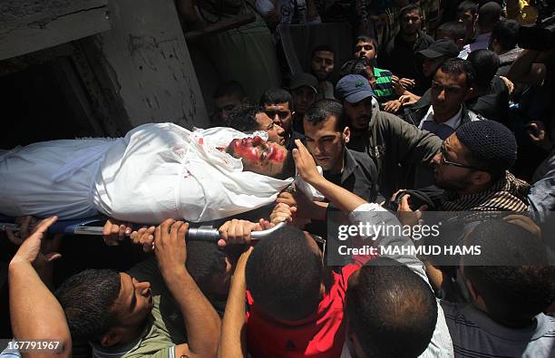 Palestinians mourners carry the body of Haitham Al-Meshal, during his funeral in Gaza City, on April 30, 2013. An Israeli air strike on Gaza City...