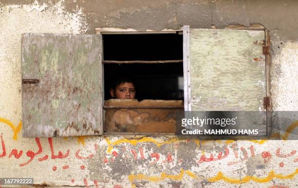 Young boy sits at the window of the home of Haitham Al-Meshal, during his funeral in Gaza City, on April 30, 2013. An Israeli air strike on Gaza City...