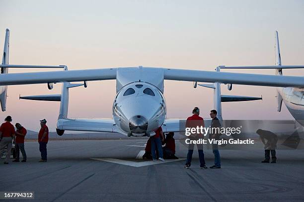 Crew chief, Steve Losey and aerospace engineer, Jason DiVenere discuss last minute pre-flight details, prior to the first powered flight of Virgin...