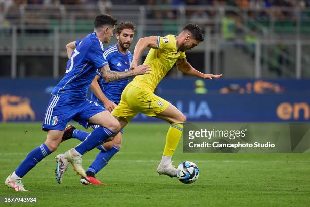 Roman Yaremchuk of Ukraine competes for the ball with Alessandro Bastoni and Manuel Locatelli of Italy during the UEFA EURO 2024 European qualifier...