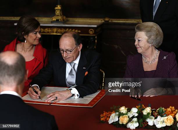 Dutch politician Fred de Graaf signs of the Act of Abdication as Queen Beatrix of the Netherlands looks on during a ceremony in the Moseszaal at the...