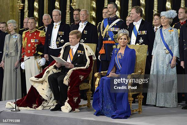 King Willem Alexander of the Netherlands and HM Queen Maxima of the Netherlands sit on their thrones in front of members of the royal household...