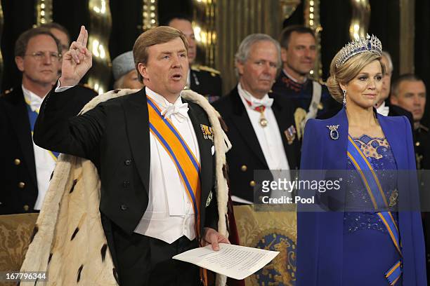 King Willem Alexander of the Netherlands takes the oath as his wife HRH Queen Maxima of the Netherlands looks on during their inauguration ceremony...