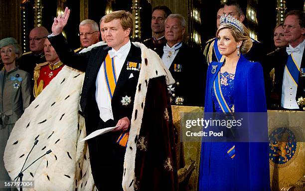 King Willem Alexander of the Netherlands takes the oath as HM Queen Maxima of the Netherlands looks on near members of the royal household during...