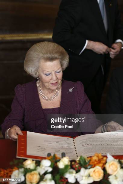 Queen Beatrix of the Netherlands signs the Act of Abdication during a ceremony in the Moseszaal at the Royal Palace on April 30, 2013 in Amsterdam....