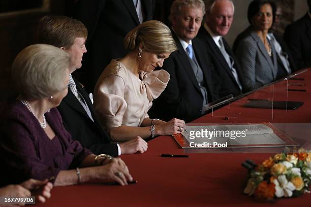Princess Maxima of the Netherlands signs the Act of Abdication as Queen Beatrix of the Netherlands and her son Prince Willem-Alexander of the...