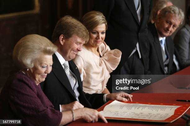 Prince Willem-Alexander of the Netherlands signs the Act of Abdication during the abdication ceremony for his mother Queen Beatrix of the Netherlands...