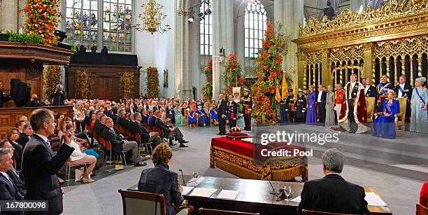 King Willem Alexander of the Netherlands takes the oath as HM Queen Maxima of the Netherlands looks on near members of the royal household during...