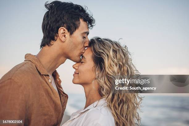 hombre besando a la mujer - caricia fotografías e imágenes de stock