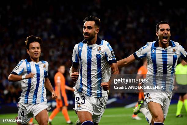 Real Sociedad's Spanish midfielder Brais Mendez celebrates with teammates after scoring his team's first goal during the UEFA Champions League 1st...