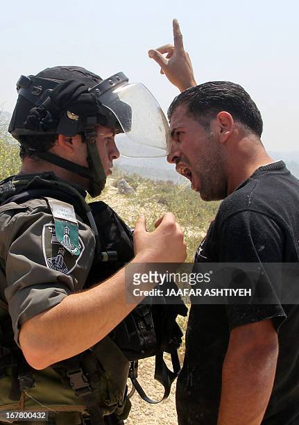 Palestinian man shouts at a member of the Israeli security forces during clashes between Palestinians and Israeli settlers in the West Bank village...