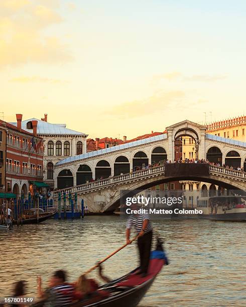 gondola moving in front of rialto bridge, venice - rialto bridge stock pictures, royalty-free photos & images