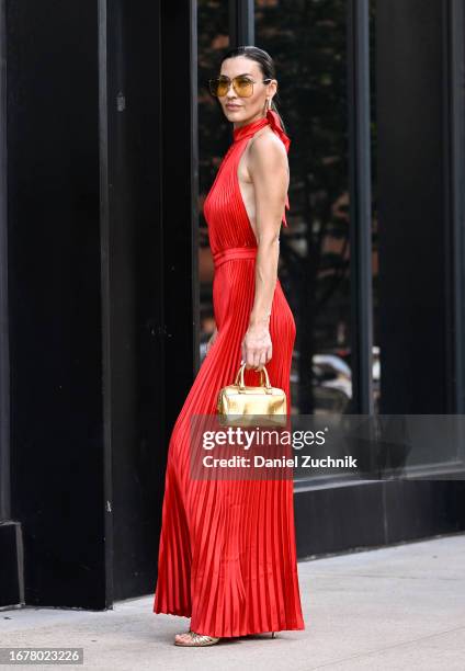 Yana Echko is seen wearing a L'IDEE jumpsuit, Saint Laurent bag, Gucci sunglasses, and Stuart Weitzman shoes with Kenneth Jay Lane jewelry during...