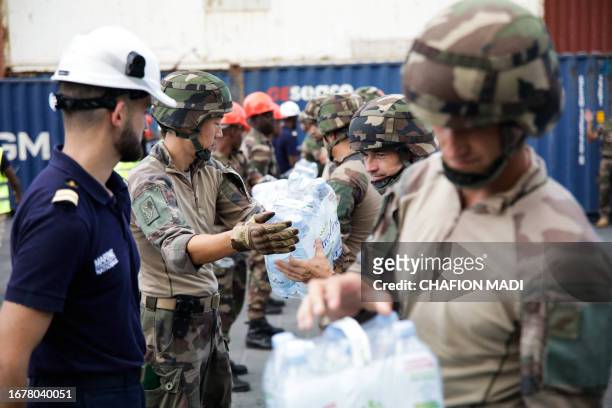 Soldiers unload water packs in the port of Longoni, following the arrival of a ship on the French island of Mayotte carrying 600,000 liters of...