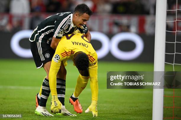 Manchester United's Spanish defender Sergio Reguilon lifts up Manchester United's Cameroonian goalkeeper Andre Onana after conceding the opening goal...