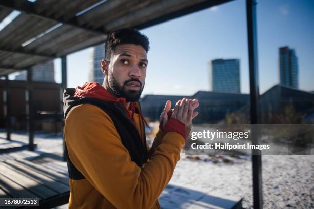 portrait of young man stretching before running in the city. - se frotter les mains photos et images de collection