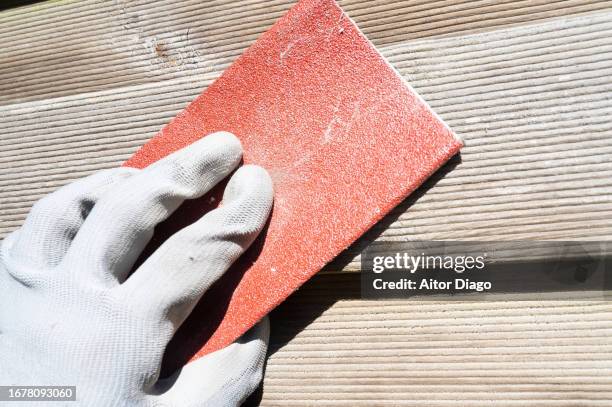 a person sanding wood by hand in a garden. conservation and maintenance work - sand paper stock pictures, royalty-free photos & images