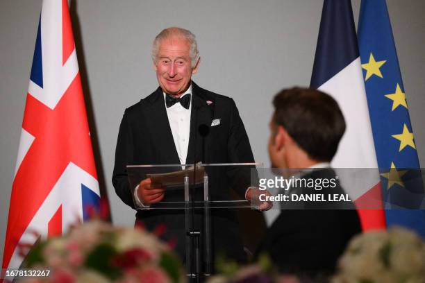 Britain's King Charles III delivers a speech as French President Emmanuel Macron looks on during a state banquet at the Palace of Versailles, west of...
